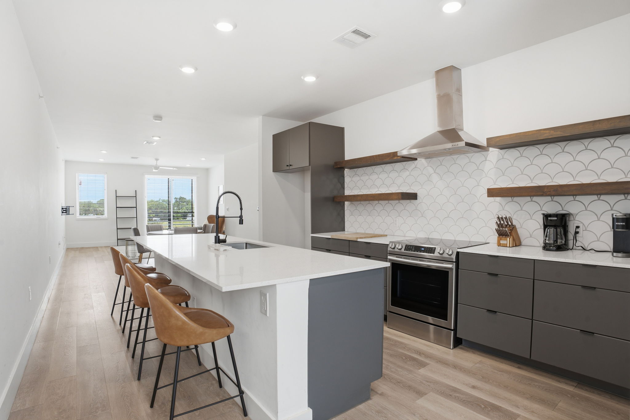 2709 East 5th Street, Unit 1306 Austin, TX 78702 - Photo 1 of 28 A sleek island kitchen featuring state-of-the-art stainless steel appliances and open wooden shelving.