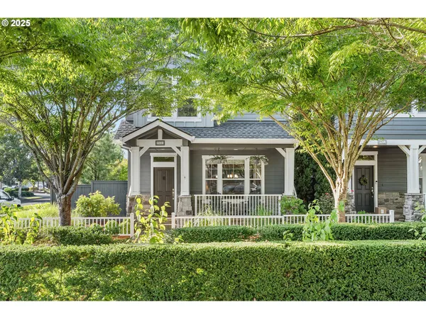 a front view of a house with a garden and trees