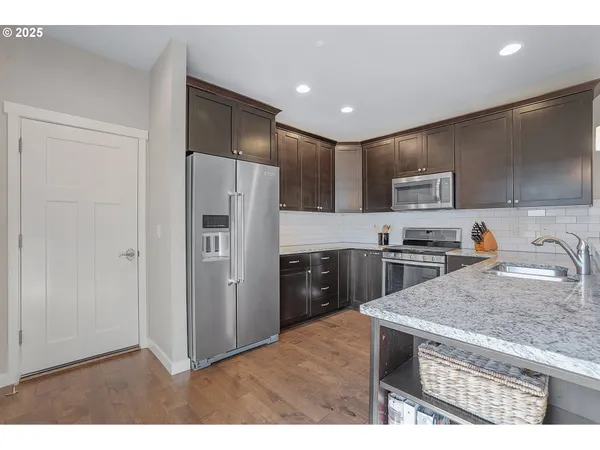 a kitchen with a refrigerator a sink a stove a microwave and cabinets