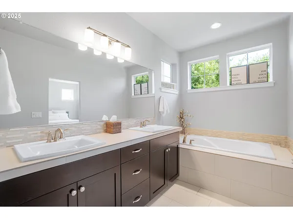 a bathroom with a tub a sink and mirror