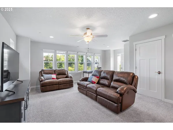 a living room with furniture a large window and a flat screen tv