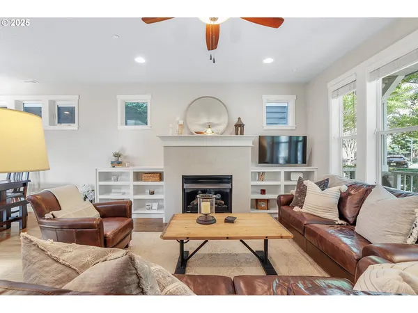 a living room with furniture a fireplace and a large window
