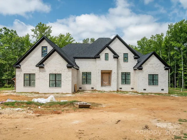 a view of house with yard and trees in the background