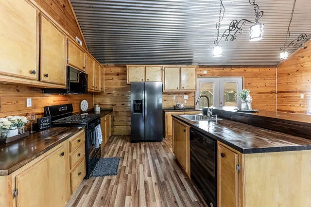 a kitchen with stainless steel appliances granite countertop a sink a stove and cabinets
