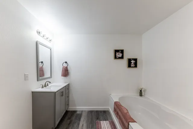 a bathroom with a granite countertop toilet sink and mirror