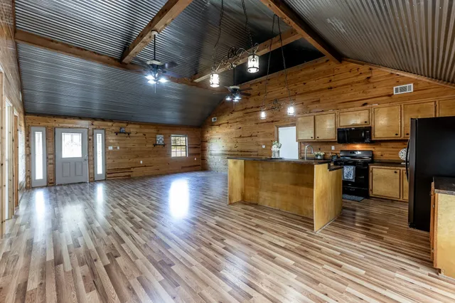 a kitchen with stainless steel appliances kitchen island granite countertop a refrigerator and a stove