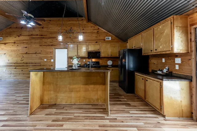 a kitchen with stainless steel appliances granite countertop a refrigerator a sink dishwasher a stove and white countertops with cabinets