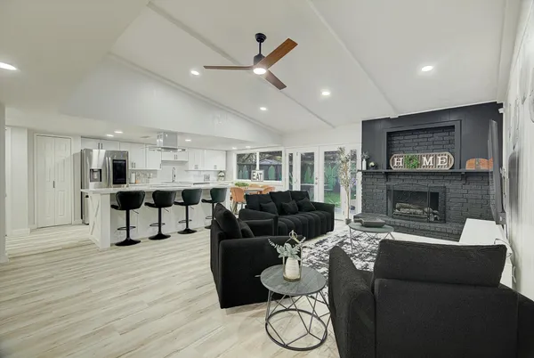a living room with furniture a flat screen tv and a fireplace
