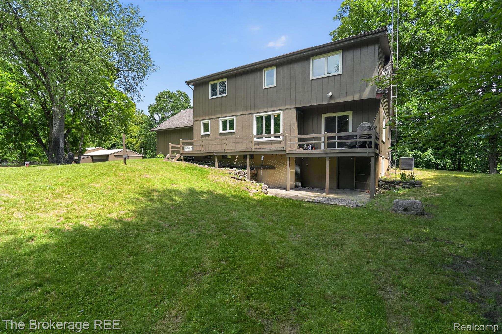 13269 North Genesee Road Clio, MI 48420 - Photo 48 of 67 Multi-level exterior with a deck, ground-level patio, and surrounding green space