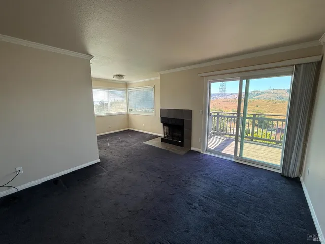 an empty room with fireplace and a window