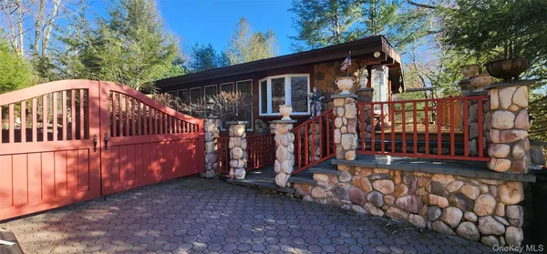 a view of wooden house with large trees and wooden fence