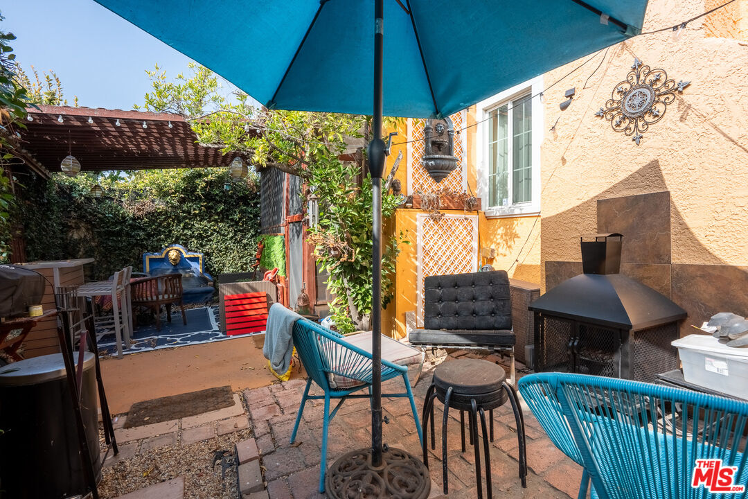 2045 Claudina Avenue Los Angeles, CA 90016 - Photo 16 of 33 a view of a patio with a table and chairs under an umbrella