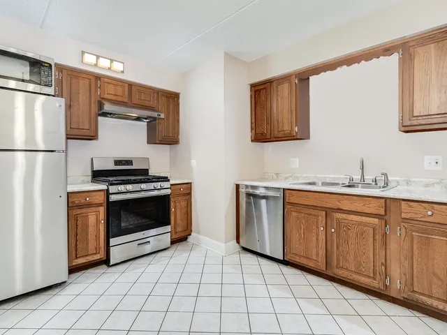 a kitchen with stainless steel appliances granite countertop a stove a sink and a refrigerator