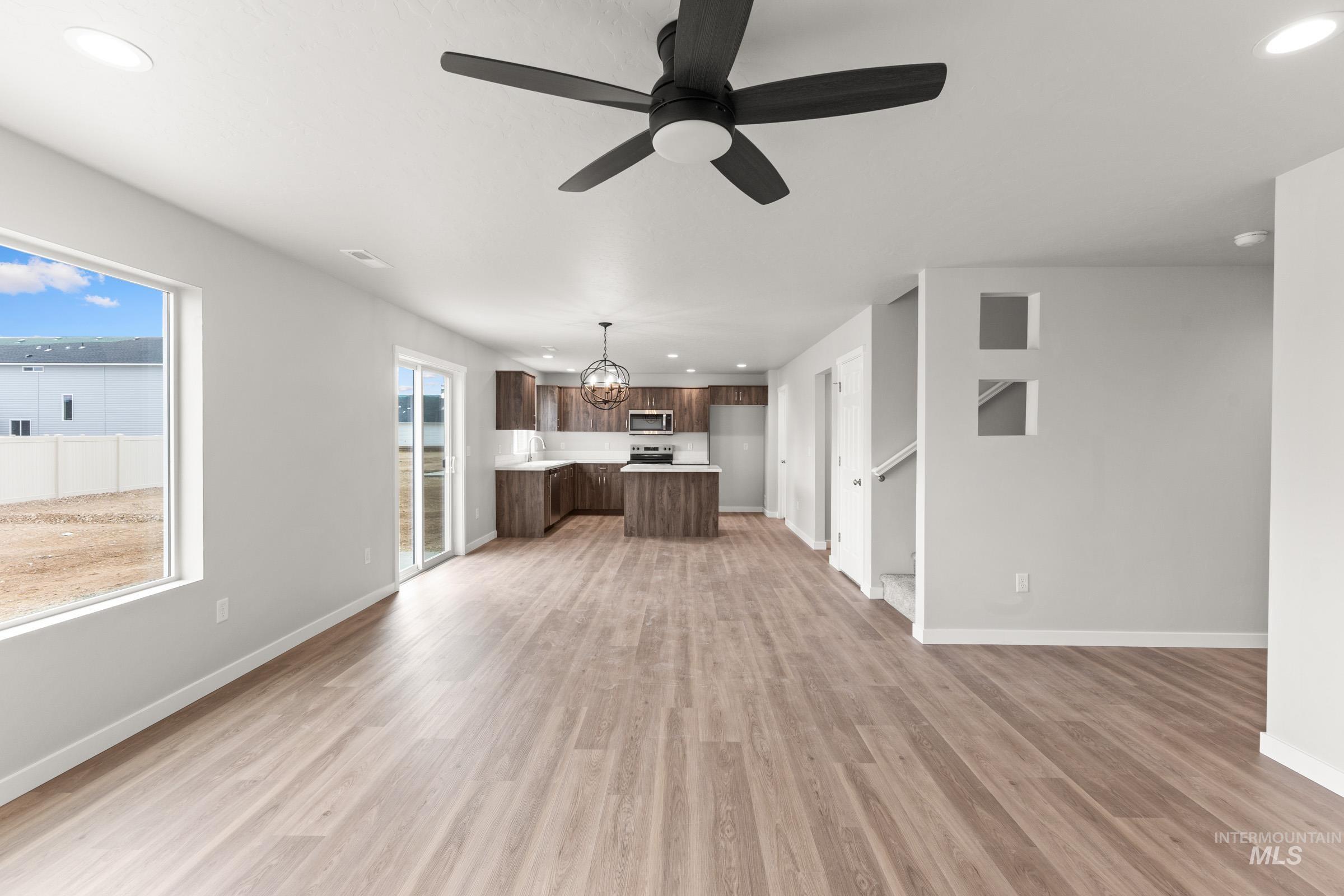 461 Waverly Avenue Middleton, ID 83644 - Photo 9 of 22 Unfurnished living room with suspended lighting, a ceiling fan, and light wood-style floors