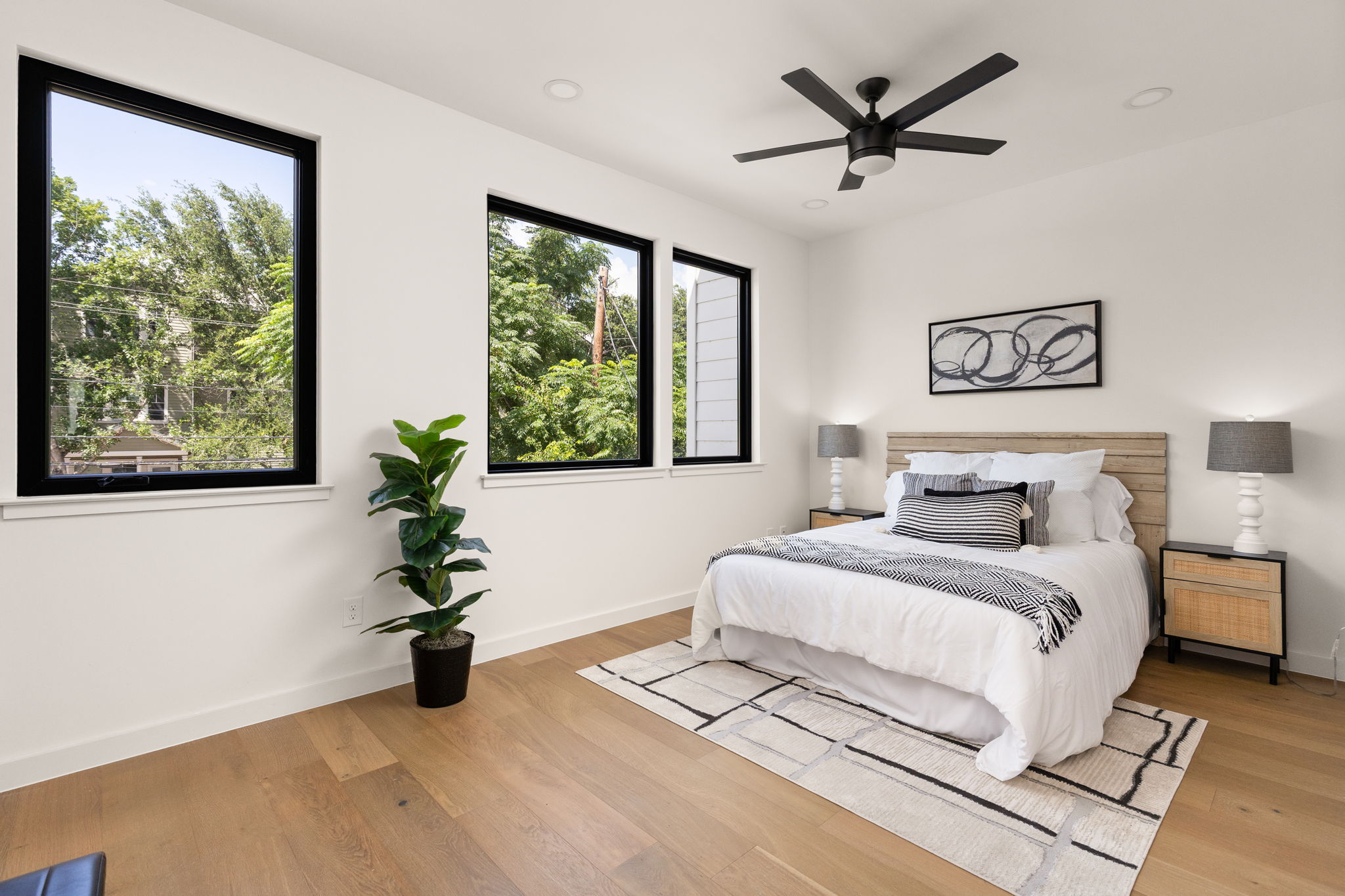 2717 Lyons Road, Unit 1 Austin, TX 78702 - Photo 18 of 40 Natural light streams into this serene bedroom, highlighting light wood flooring and modern recessed lighting.