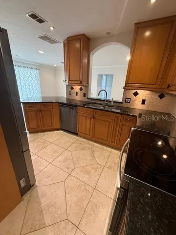 a kitchen with stainless steel appliances a sink stove and cabinets