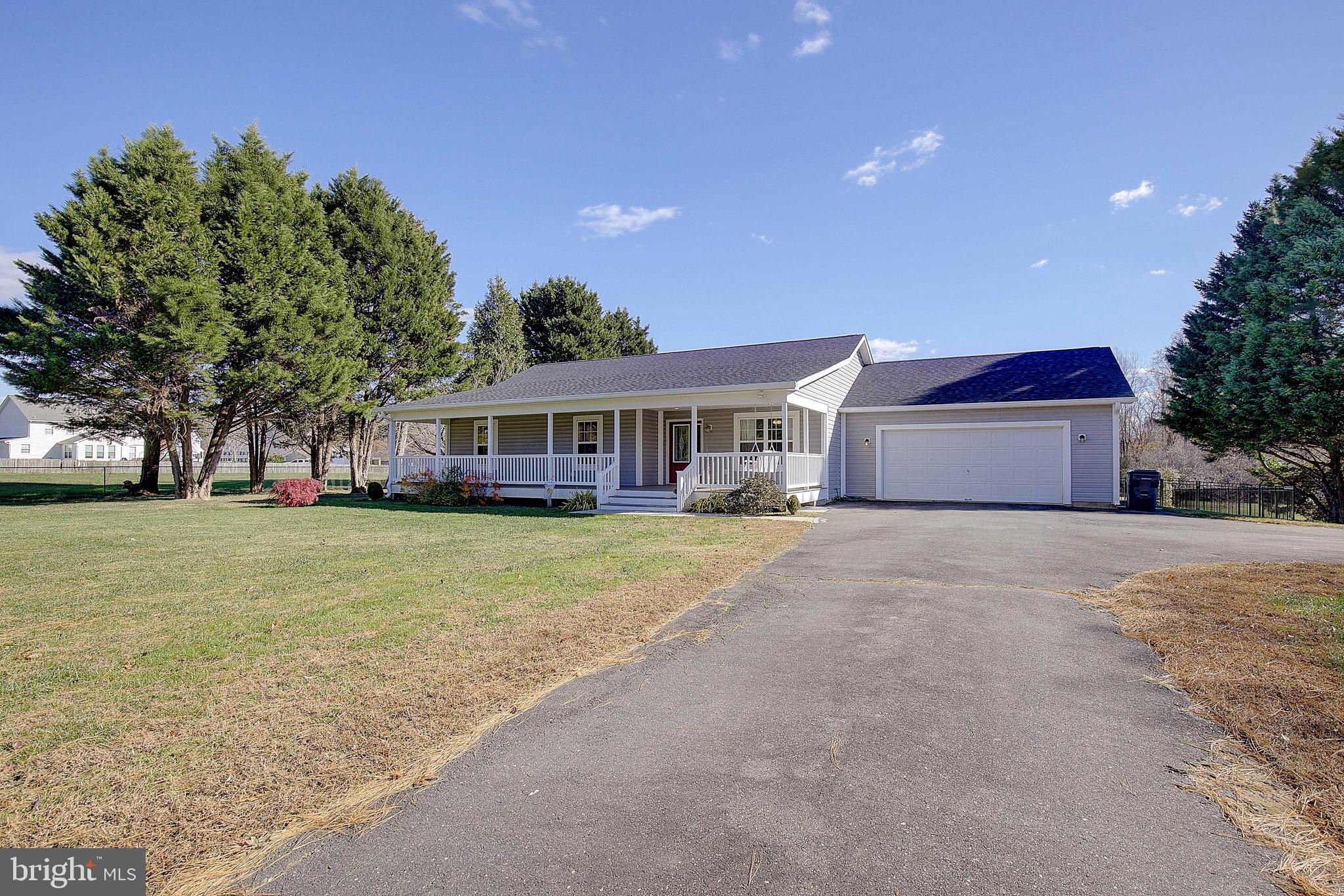 a front view of a house with a garden and tree