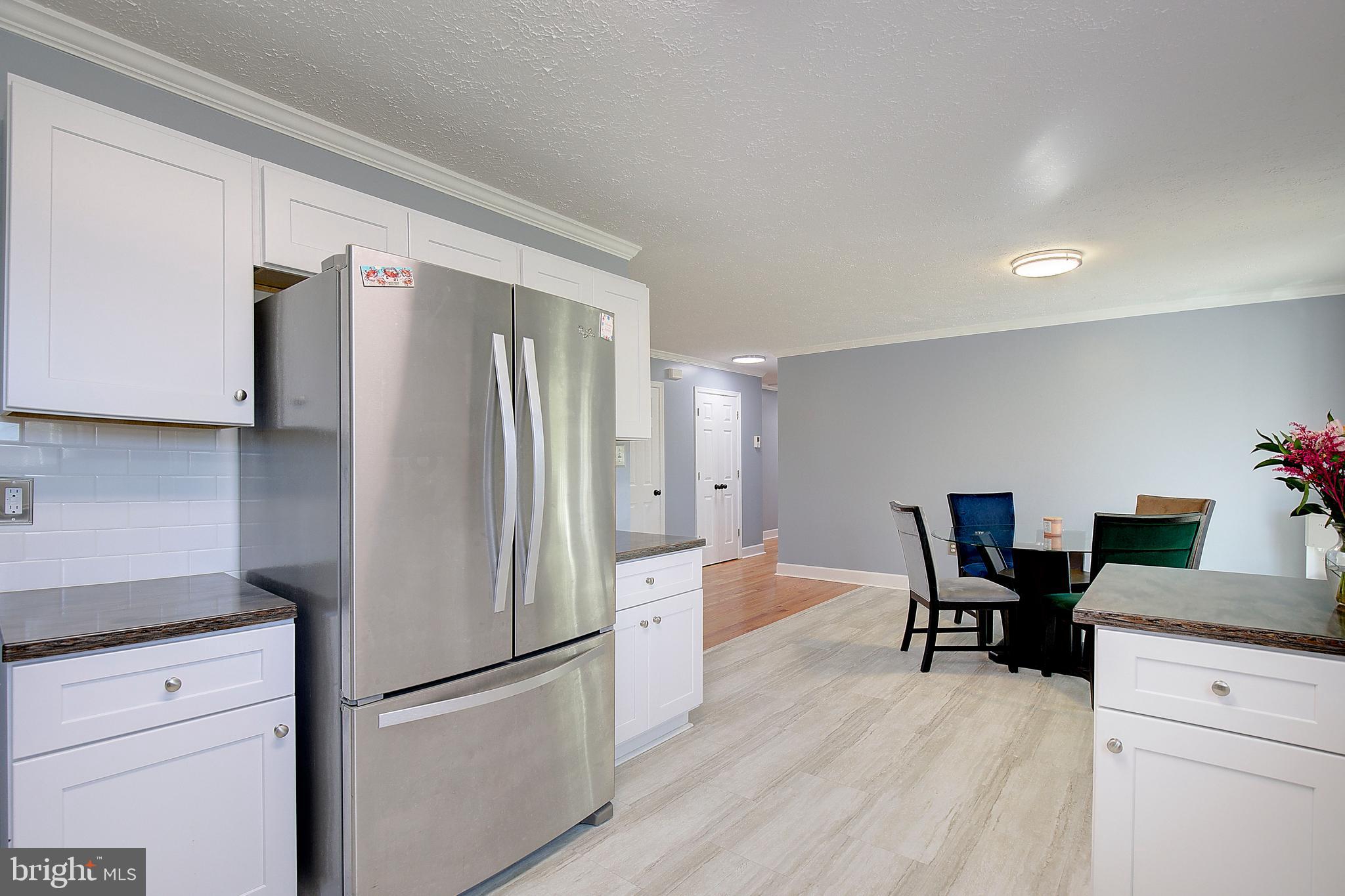26282 Rio Bravo Lane Mechanicsville, MD 20659 - Photo 16 of 52 a kitchen with stainless steel appliances a refrigerator and wooden floors