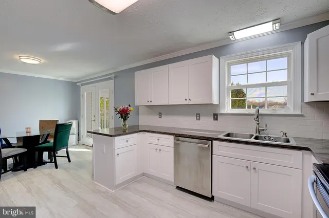 a kitchen with white cabinets sink and white appliances