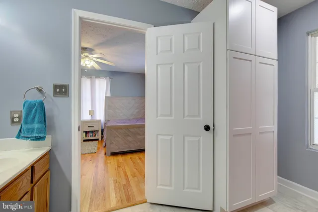 a en suite bathroom with a granite countertop sink and a mirror