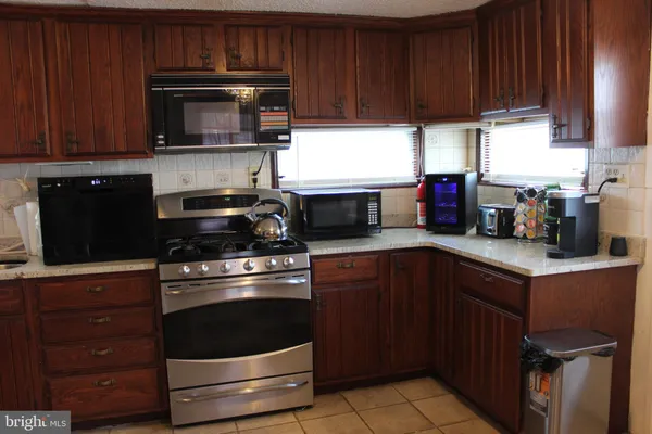 a kitchen with granite countertop wooden cabinets and stainless steel appliances