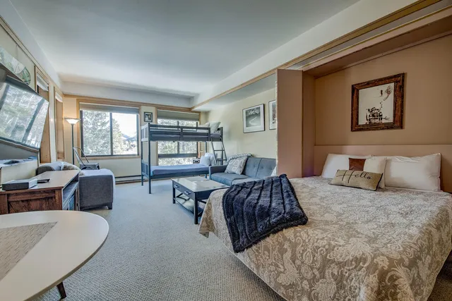 a bedroom with a large bed couch and a window