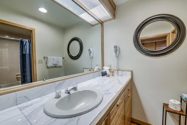 a bathroom with a granite countertop sink and a mirror