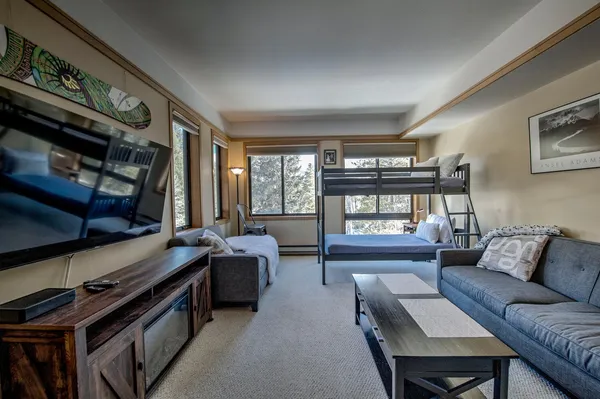 a bedroom with a bed couch and a large window