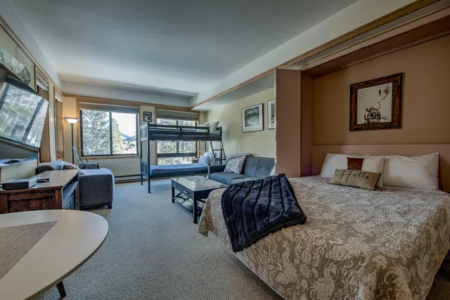 a living room with furniture a flat screen tv and a rug