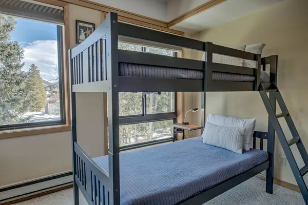 a bedroom with bunk bed and a window