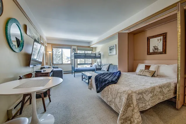 a living room with furniture a flat screen tv and a floor to ceiling window