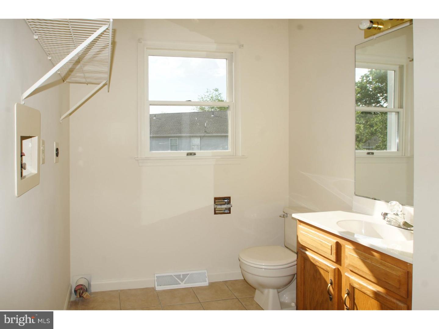1468 Pershing Boulevard Reading, PA 19607 - Photo 11 of 15 a bathroom with a granite countertop toilet a sink a mirror and a window