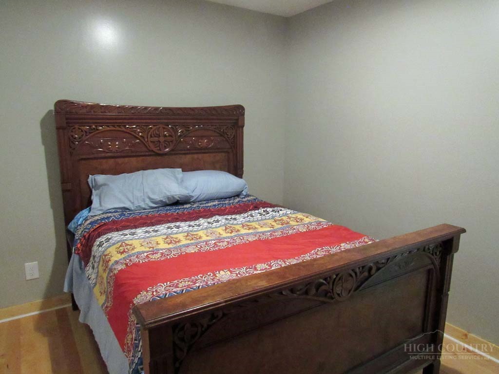 805 Ed Little Road Warrensville, NC 28693 - Photo 36 of 49 a bed sitting in a bedroom next to a window