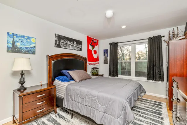 a bedroom with a bed and a lamp on dresser
