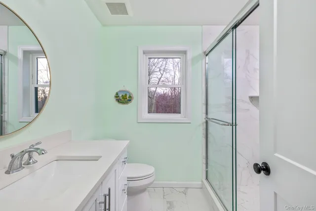 a bathroom with a sink and mirror with toilet