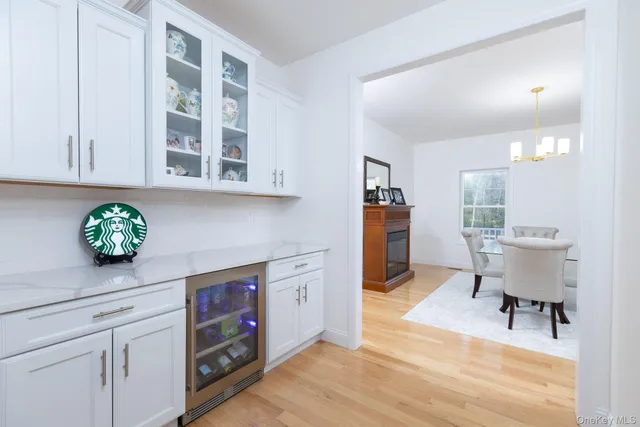 a living room with stainless steel appliances furniture a desk and chair with wooden floor