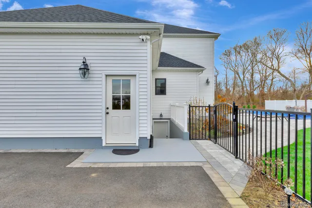 a view of a house with a white door and wooden fence