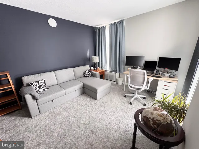 a living room with furniture a flat screen tv and a large window