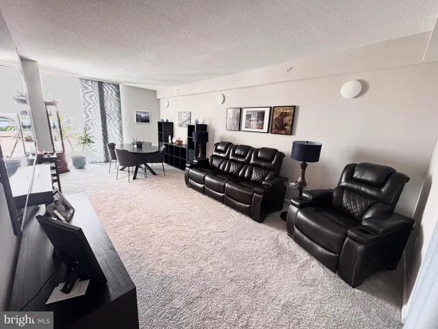 a view of a livingroom and dining room with furniture wooden floor and a rug