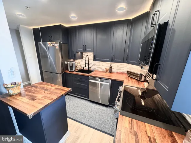 a kitchen with stainless steel appliances granite countertop a stove sink and refrigerator
