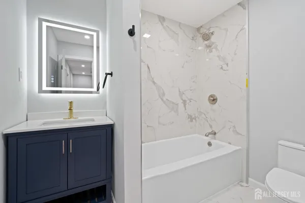 a bathroom with a bathtub shower sink and toilet