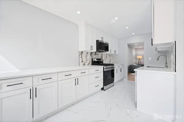 a kitchen with white cabinets and stainless steel appliances