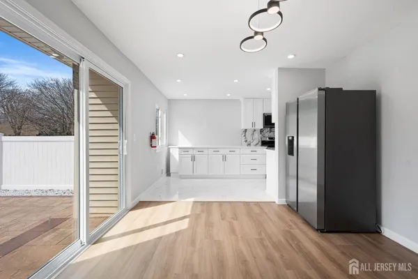 a view of a kitchen center refrigerator and wooden floor