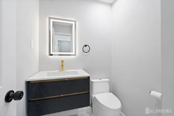 a bathroom with a toilet a sink and mirror