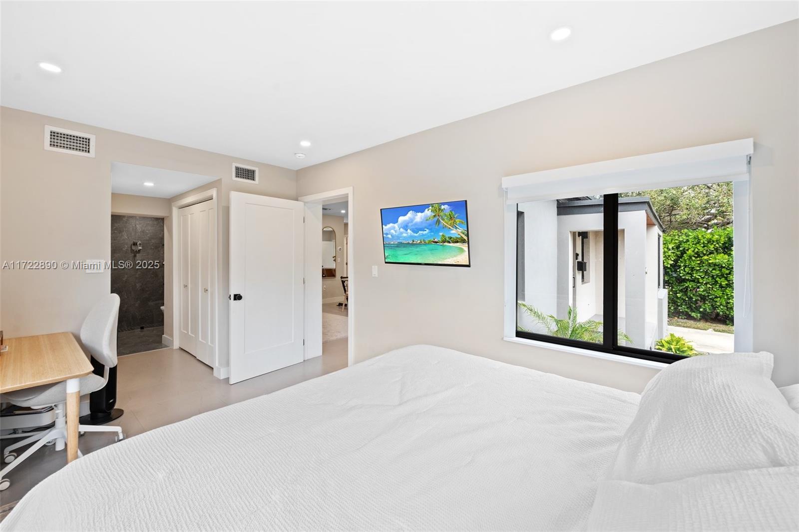 620 Cardinal Street Miami Springs, FL 33166 - Photo 13 of 24 a bedroom with a bed and a large window