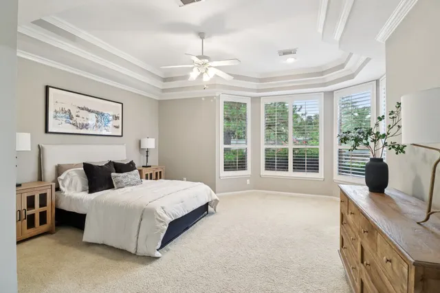 a spacious bedroom with a bed and a chandelier
