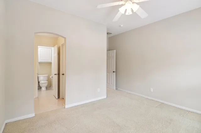 a view of house with large windows and wooden fence