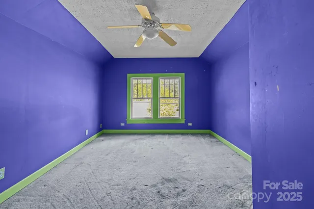 a view of a room with a ceiling fan and a window