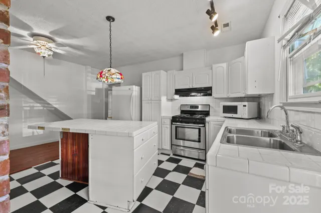 a kitchen with a checkered floor and white cabinets