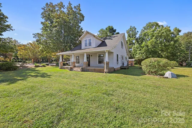 a backyard of a house with lots of green space and fountain